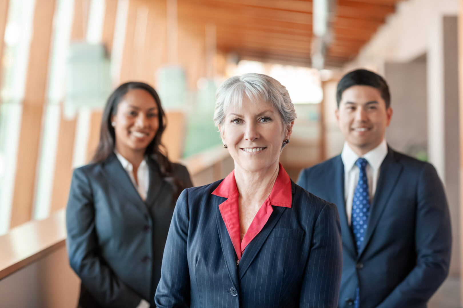 Three executives standing confidently indoors